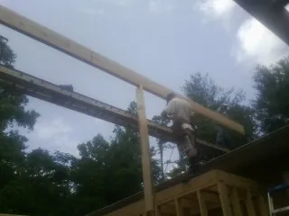 Carpenter setting a ridge beam over a new addition frame — Ice Dam Removal by Roofing Brothers in East Hartland