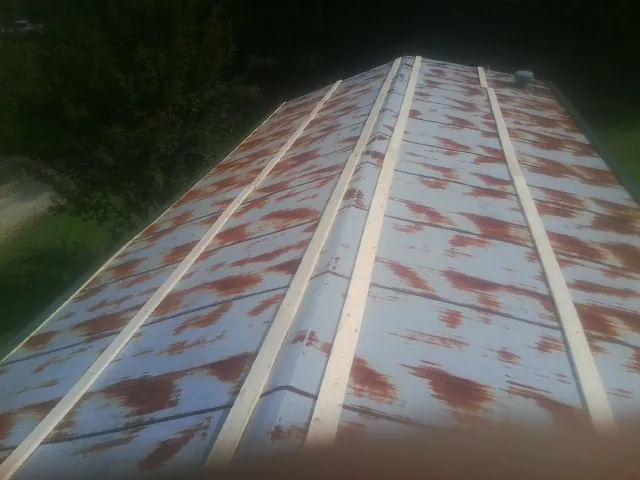 Rusted metal roof panels with new wood purlins before replacement — Storm Damage Roof Repair in East Hartland by Roofing Brothers