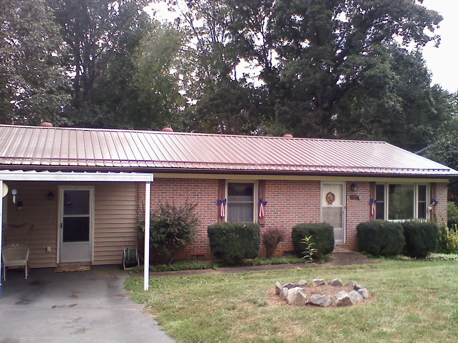 Bronze metal roof and carport on a brick ranch home — Roof Repair work by our crew in East Hartland
